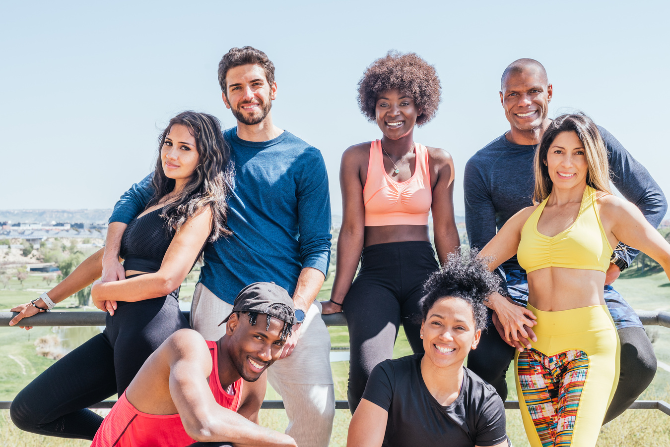 Smiling Diverse Group of Friends in Fitness Wear Crouching and S